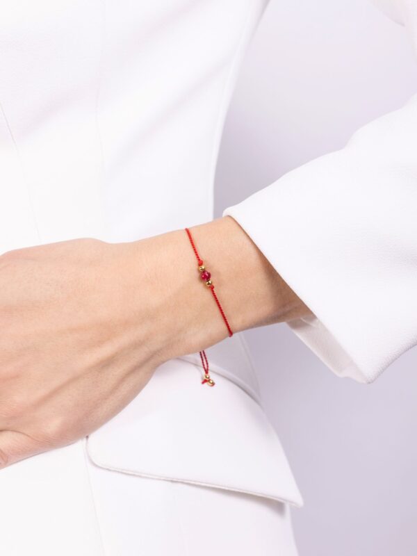 bransoletka z jaspisem cesarskim na czerwonym sznurku na ręce