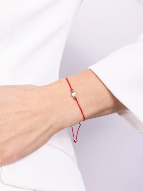 bransoletka z kamieniem księżycowym na czerwonym sznurku na ręce
