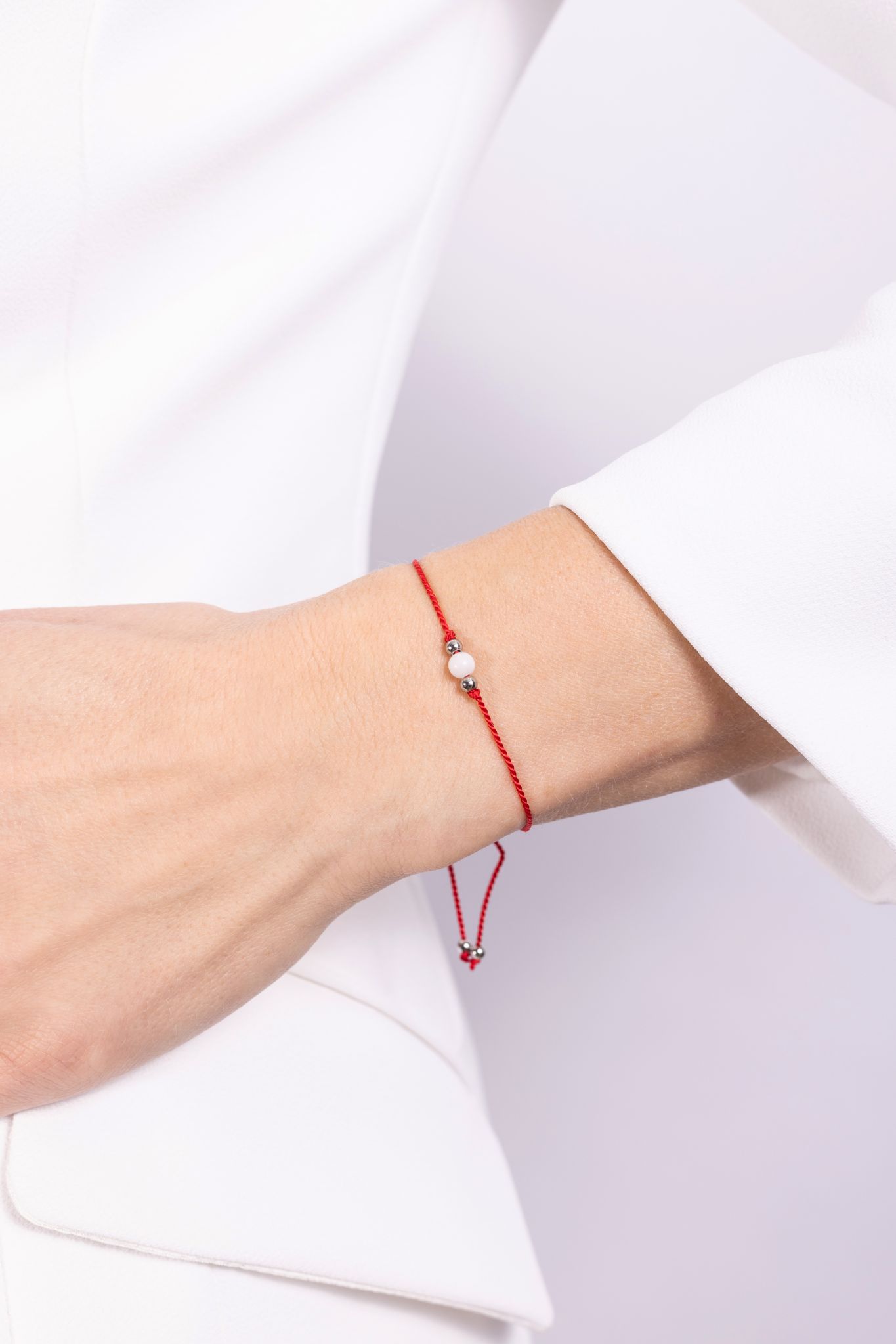 bransoletka z kamieniem księżycowym na czerwonym sznurku na ręce