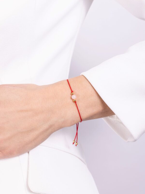 bransoletka z kwarcem różowym na czerwonym sznurku na ręce