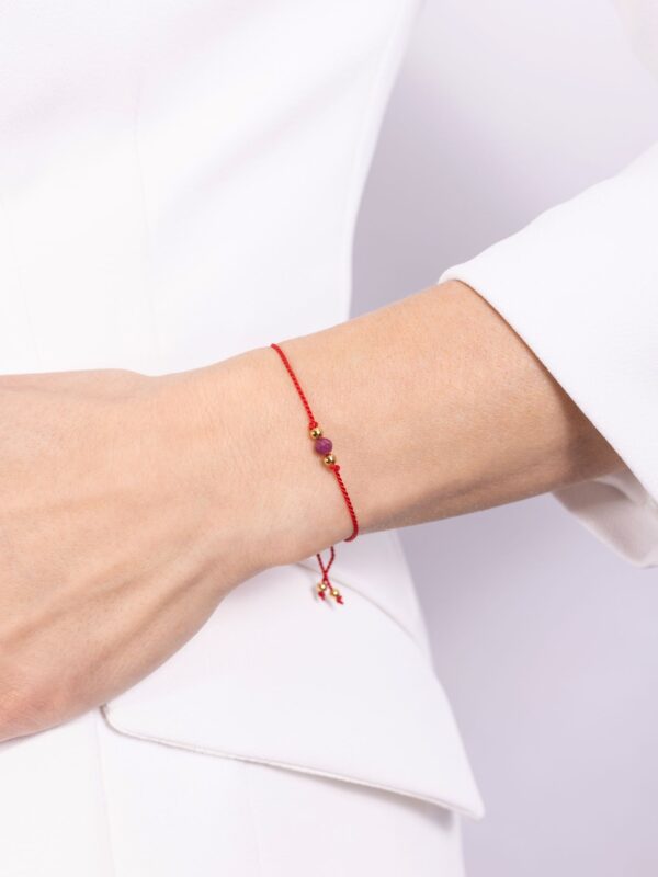 bransoletka z rubinem na czerwonym sznurku na ręce