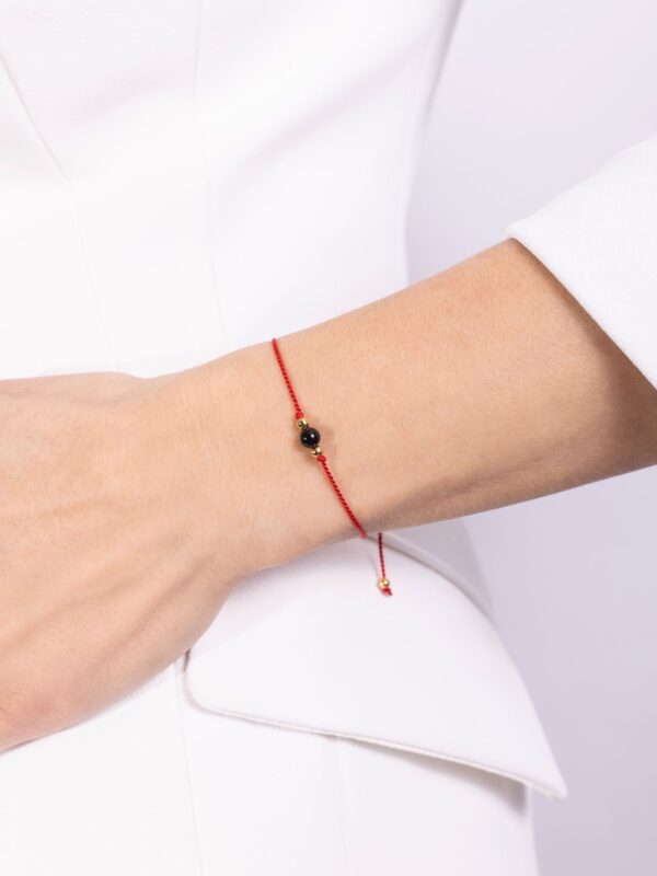 bransoletka szczęścia z turmalinem na czerwonym sznurku na nadgarstku
