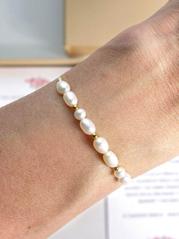 bransoletka z perłami na nici na ręce