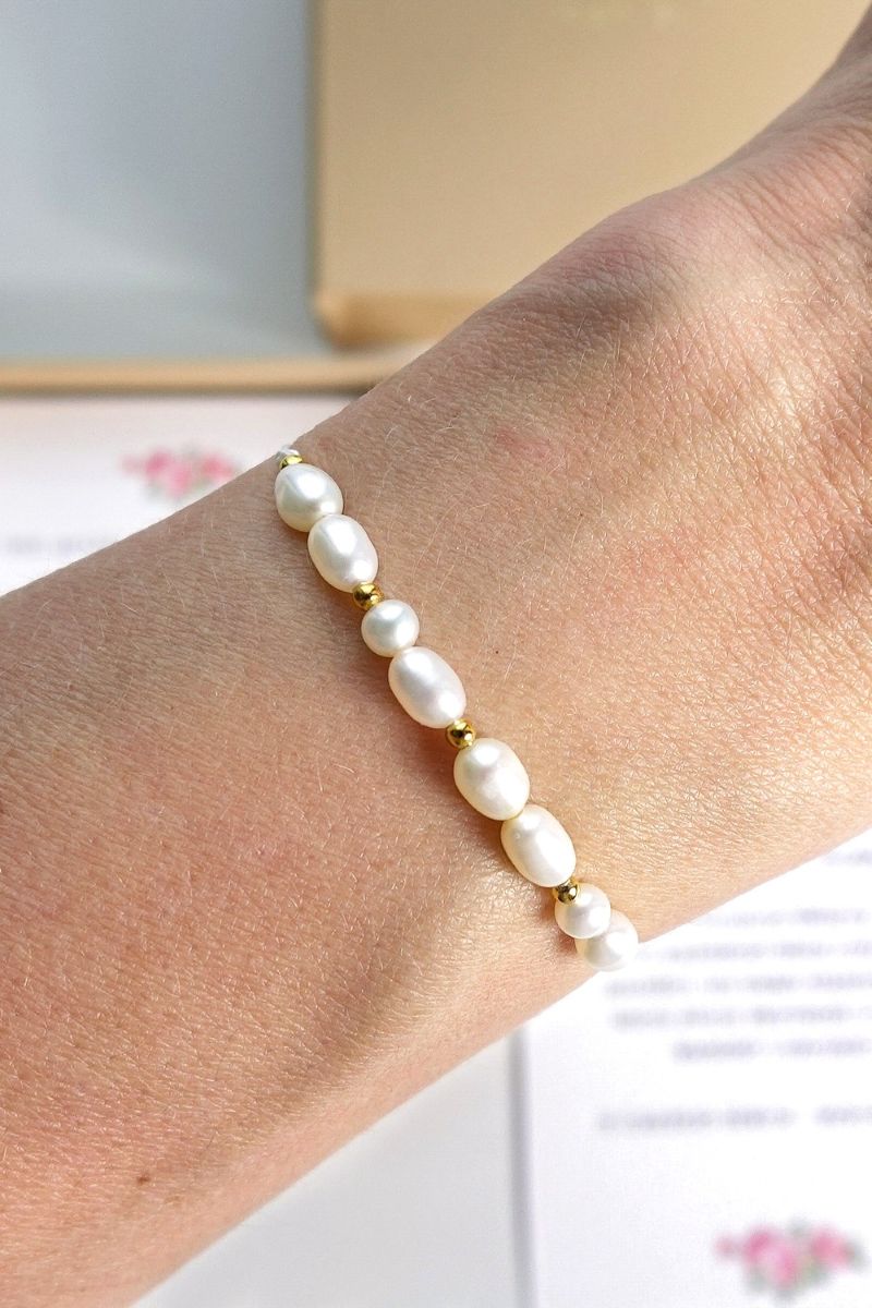 bransoletka z perłami na nici na ręce