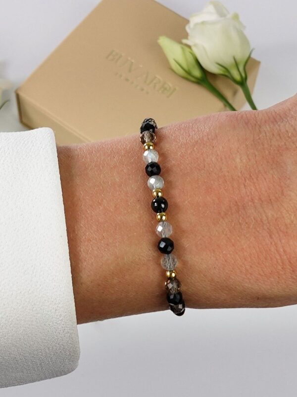 Bransoletka z turmalinem, labradorytem i kwarcem dymnym na nadgarstku.