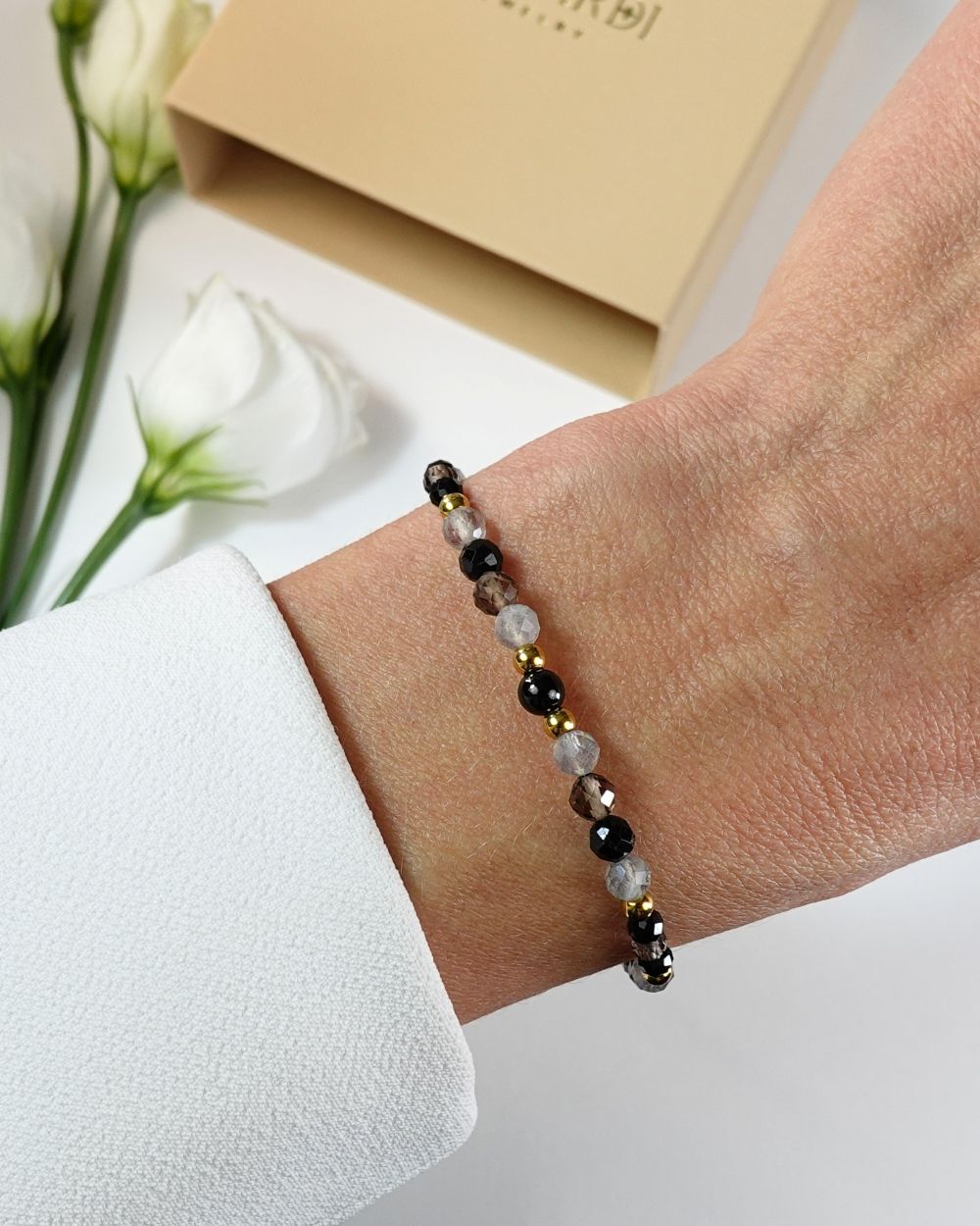 Bransoletka damska z czarnym turmalinem, talizman ochronny, na nadgarstku.