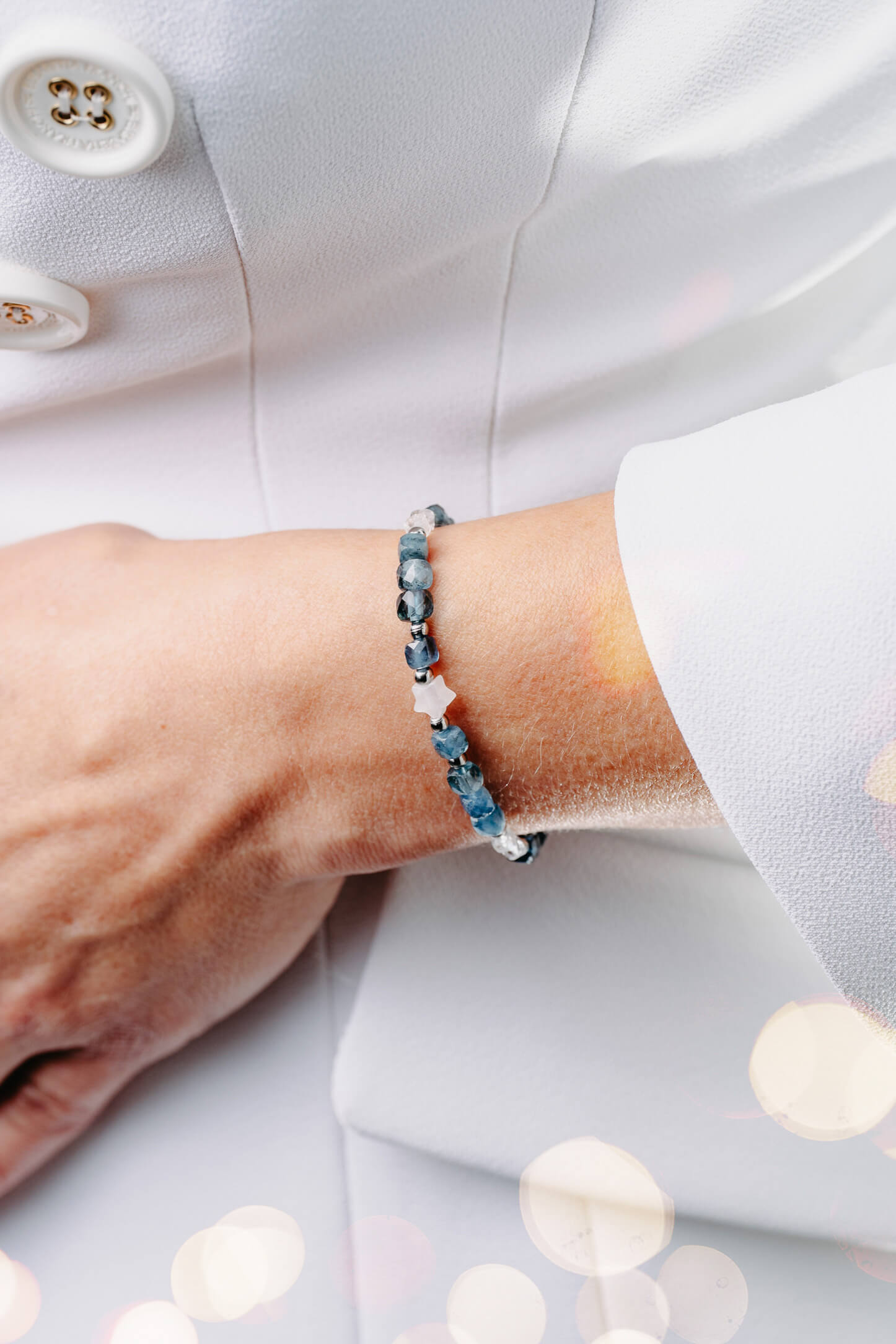 Bransoletka z ciemnego akwamarynu z kryształem górskim i gwiazdką na nadgarstku.