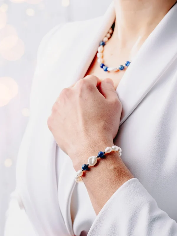 Bransoletka z perłą barokową, białymi dużymi perłami słodkowodnymi i niebieskim kianitem, na nadgarstku.