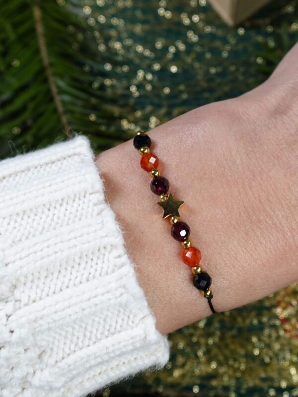 Bransoletka "Życzę Ci" z karneolem na nadgarstku.