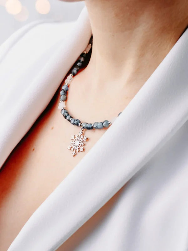 Naszyjnik z akwamarynem i zawieszką śnieżynka na modelce.