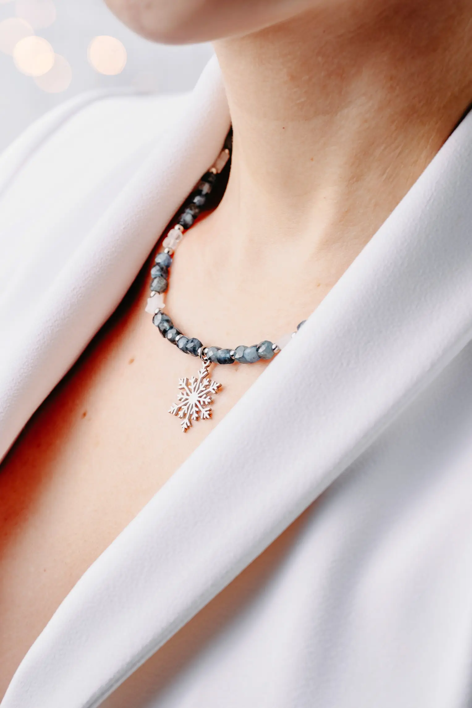 Naszyjnik z akwamarynem i zawieszką śnieżynka na modelce.