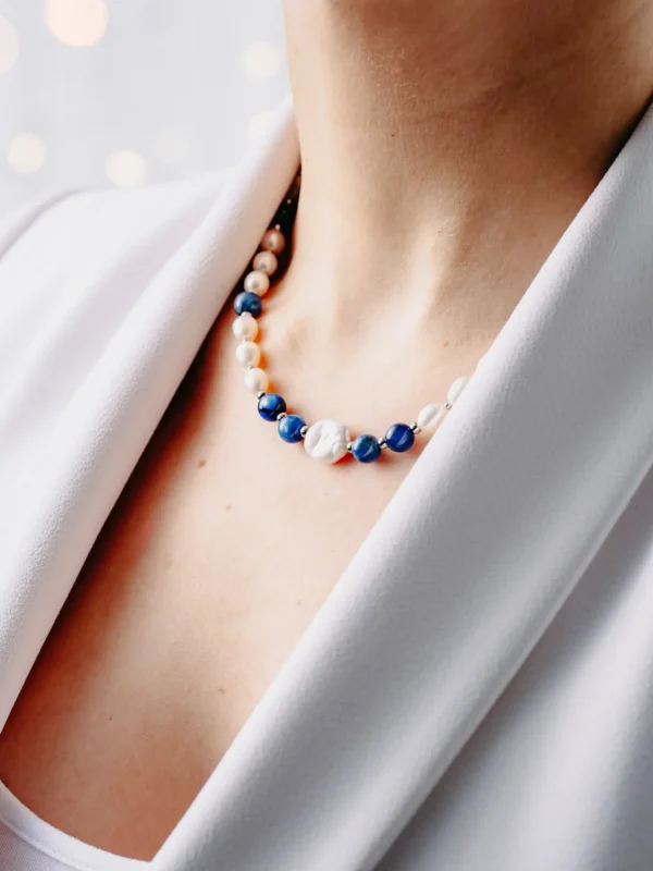 Naszyjnik z pereł naturalnych i kianitu – kamienia półszlachetnego, na szyi.